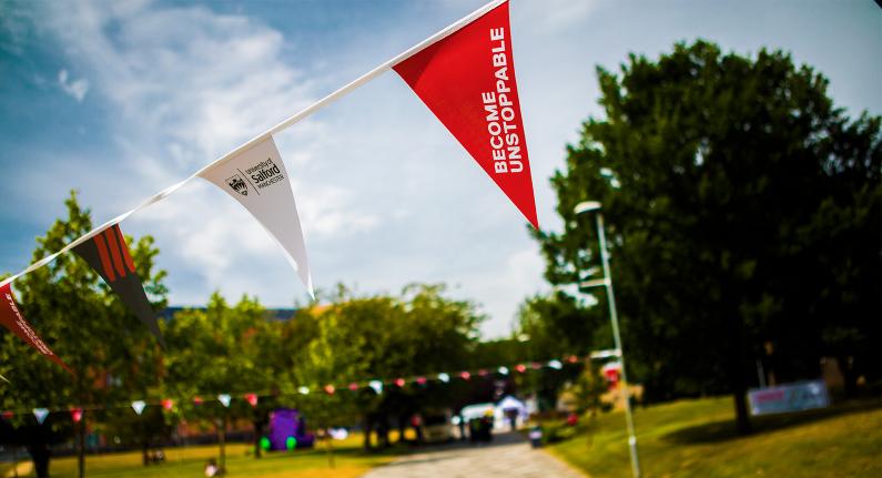 Open day bunting hanging in Peel Park, University of Salford